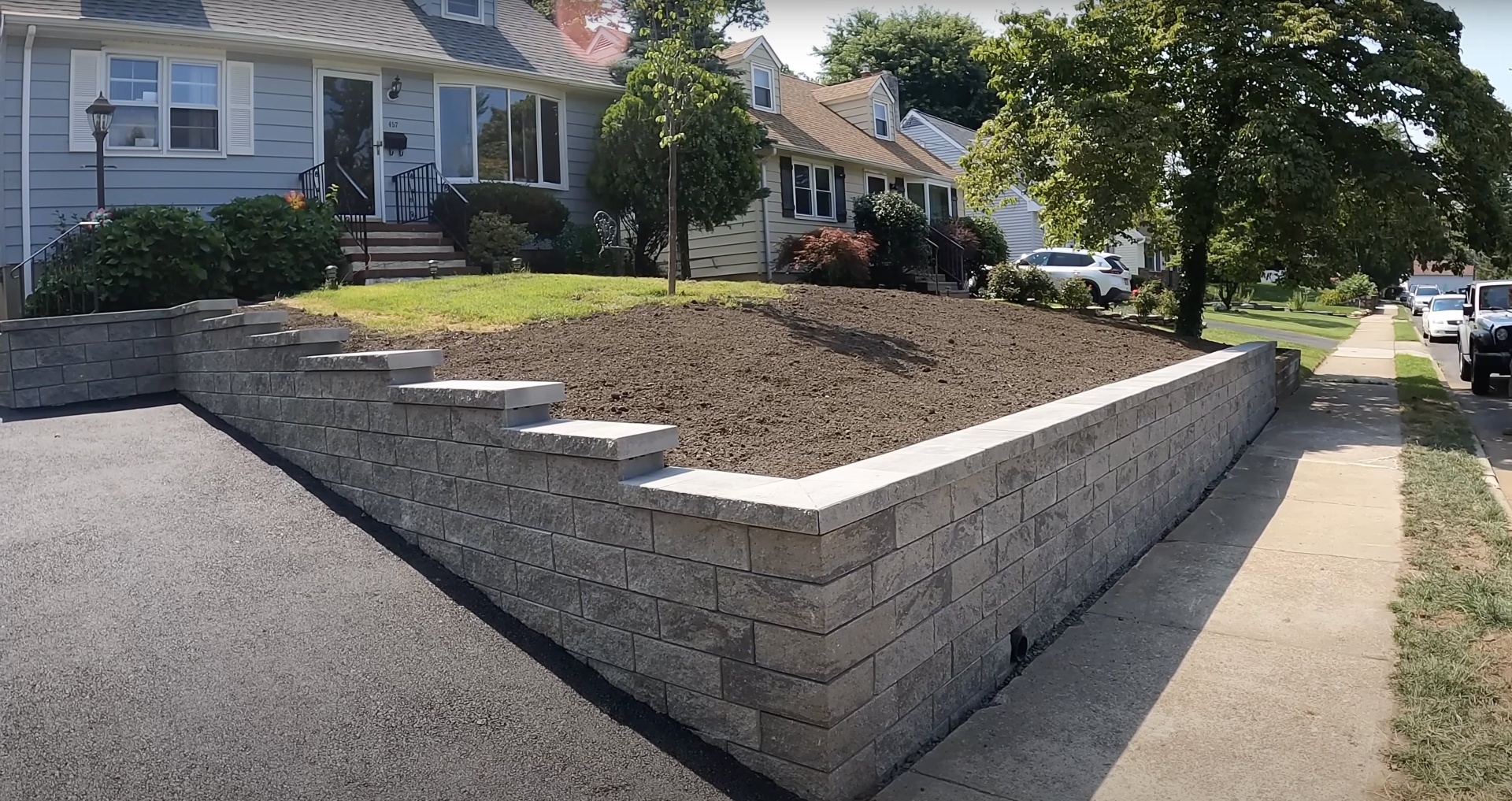 Completed residential concrete project showing retaining walls and landscaping