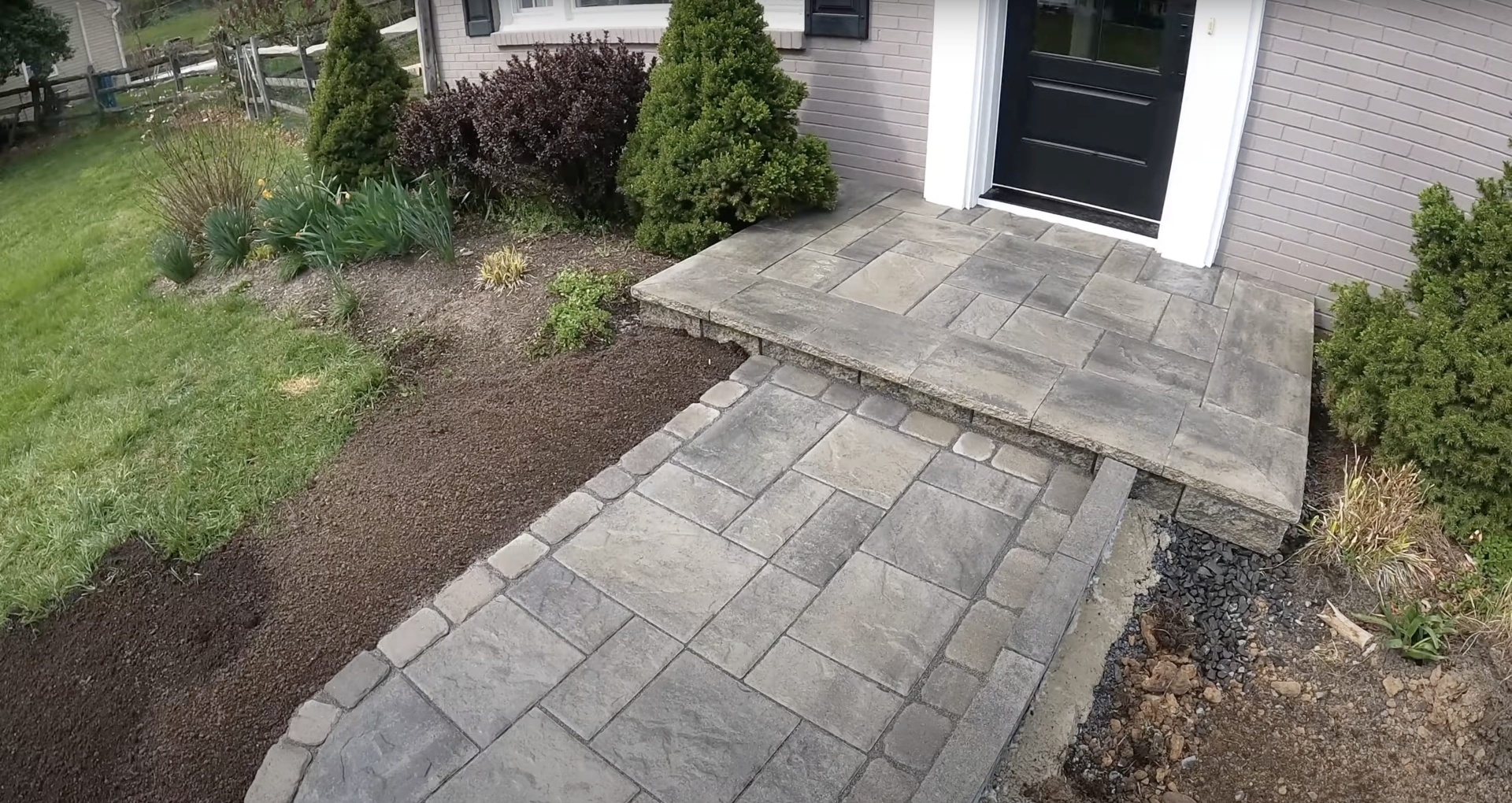 Stamped concrete entrance walkway with decorative pattern leading to front door